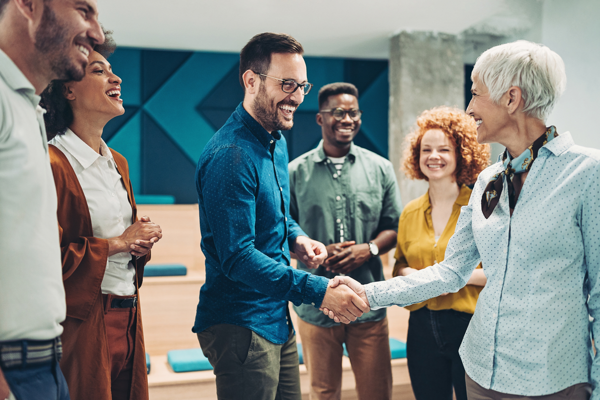 A diverse group of professionals shaking hands in an office setting.