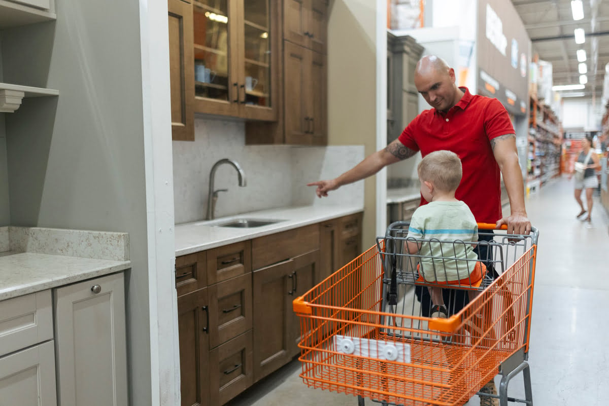 A man and a child with a shopping cart in a store