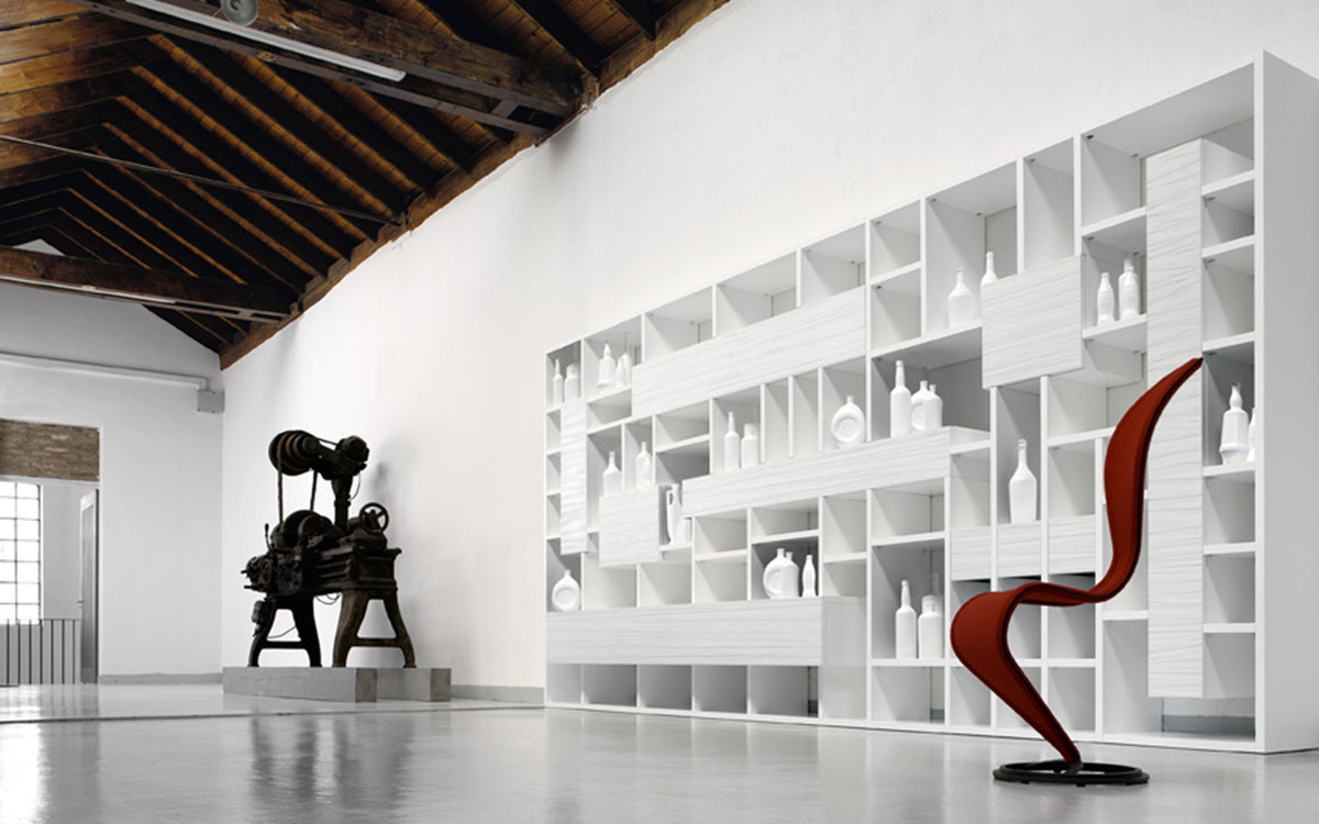 A contemporary room featuring white walls and a red chair.