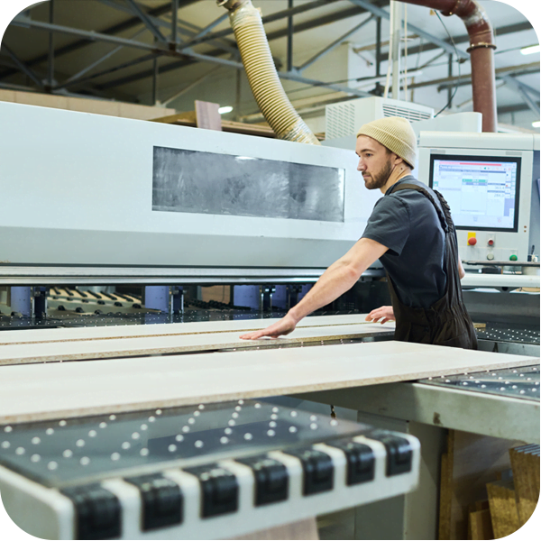 A man operates a machine in a factory setting