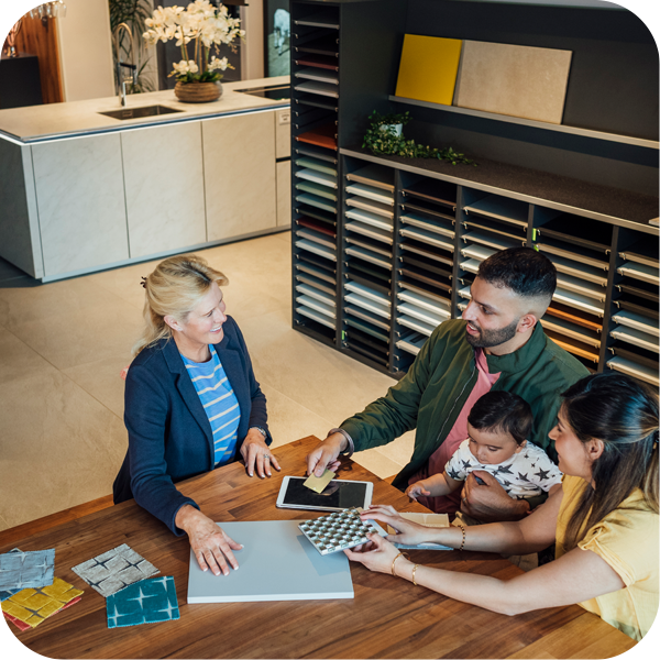 A family with a child is engaged in conversation with a woman designer.