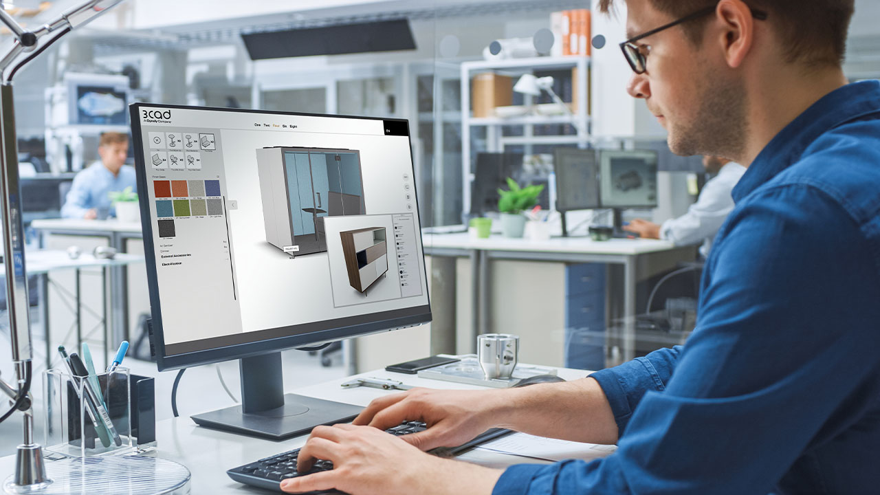 A man focused on his computer screen, working on a design project.