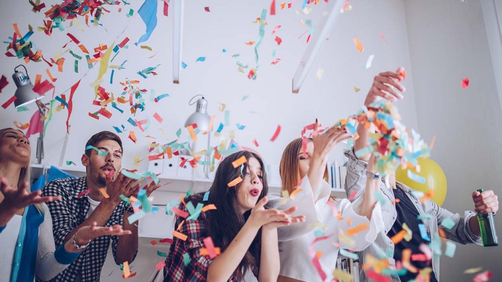 A group of people joyfully celebrating with confetti.