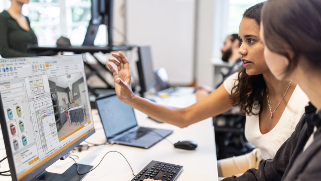 Two women collaborating on a computer screen.