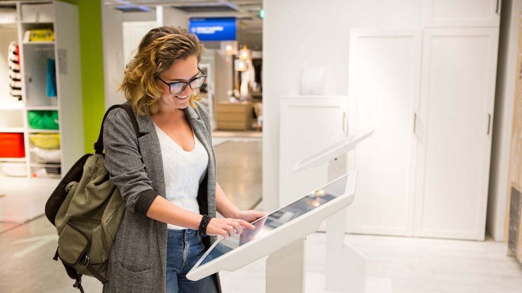 Woman browsing on tablet in retail store.