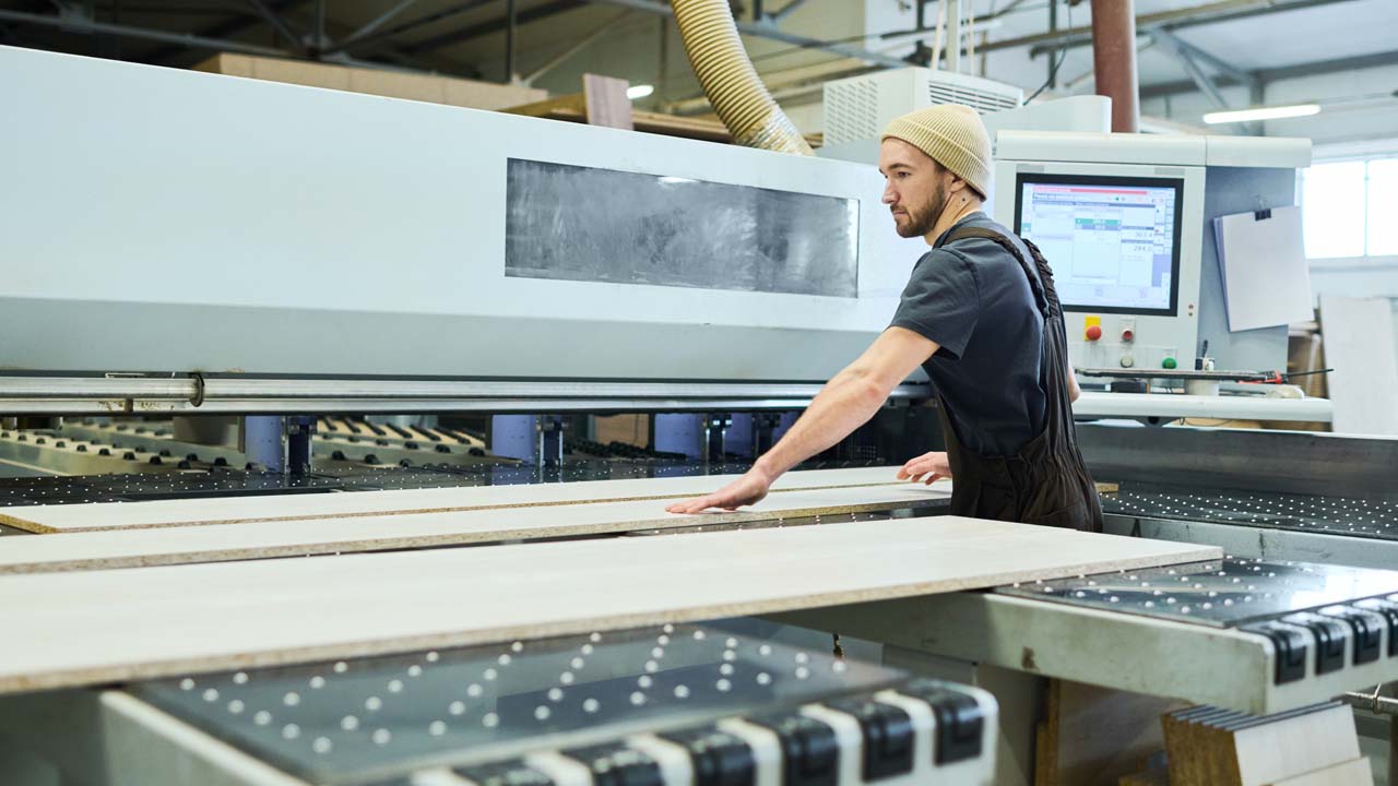 A man operates a machine in a factory.