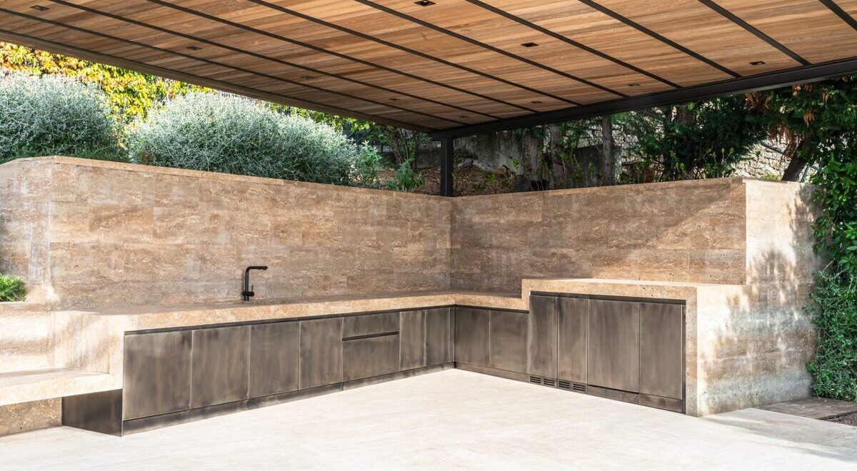 Outdoor kitchen with stone countertop, featuring sleek design and modern appliances.