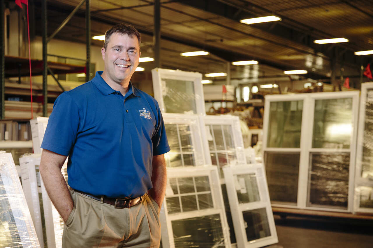 A man stands in a window warehouse