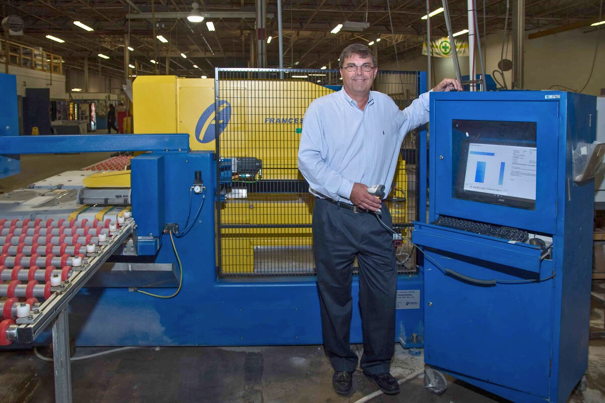 A man stands beside a machine in a factory