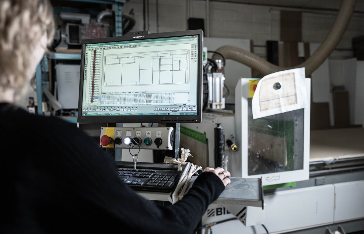 A woman engaged in computer work within a factory